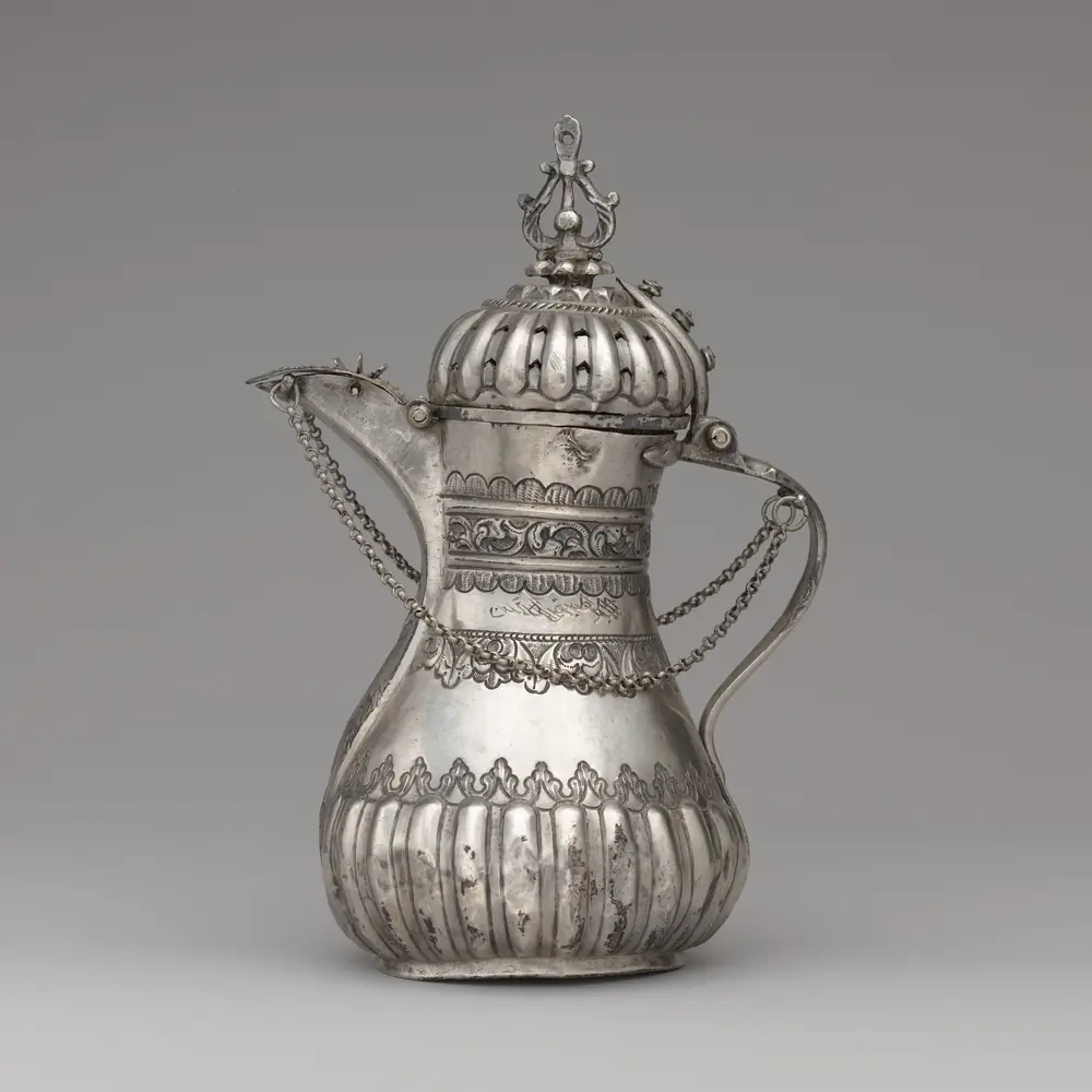 Photographie d’une cafetière en argent partiellement doré, XIXᵉ siècle, à couvercle bombé et chaînettes : une pièce acquise auprès d’un particulier, dont on note qui l’a cédée et à quelle date.