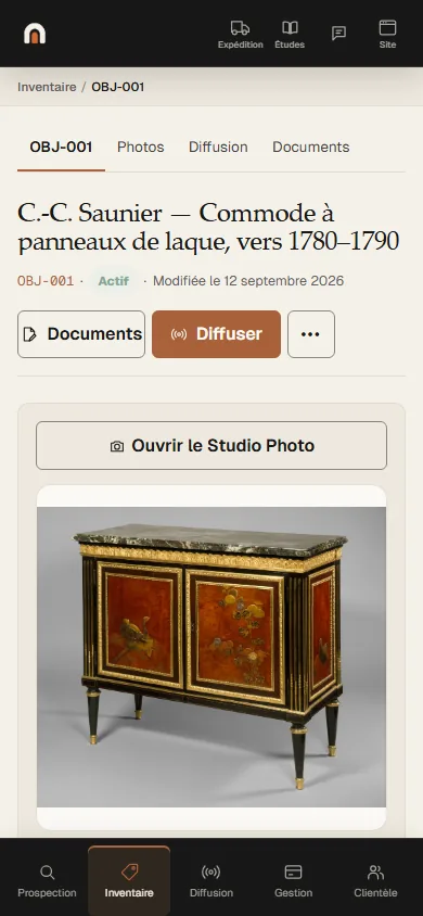 Écran de l’application Antikium : la fiche de la commode à panneaux de laque, avec sa référence, son statut, ses onglets Photos, Diffusion et Documents, et la vue préparée de la pièce sous le titre.