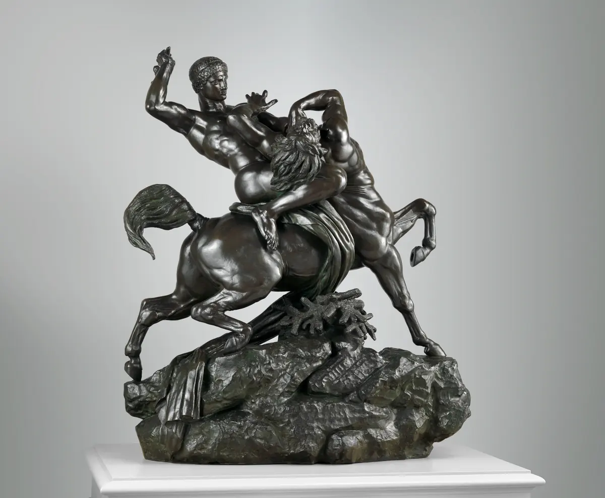 Bronze d’un cavalier combattant un centaure, photographié sur son socle de présentation : la vue d’origine, avec sa marge et son socle.